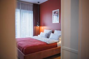 柏林瑟克斯公寓式酒店的一间卧室设有一张红色墙壁和窗户的床