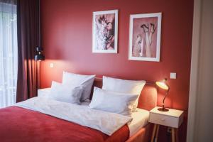 柏林瑟克斯公寓式酒店的卧室设有红色的墙壁和一张带白色枕头的床
