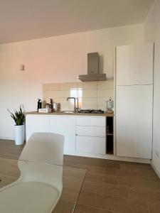 VillamassargiaLa Girandola的厨房配有白色橱柜和白色椅子
