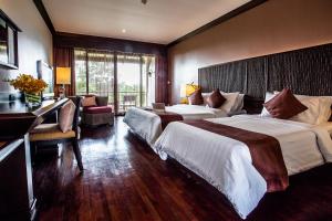 尖竹汶Maneechan Resort - SHA Extra Plus的酒店客房配有两张床和一张书桌