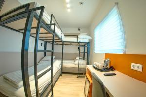维斯普雷姆Ice Premium Apartments的客房设有两张双层床和一张书桌。