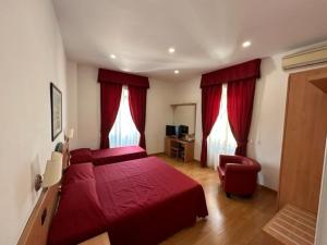 圣塔马利奈拉伊索拉酒店的一间卧室配有两张红色的床和椅子