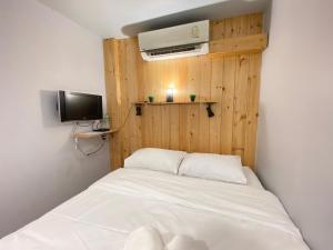 清迈THE BEST ONE CHIANG MAI的一间小卧室,配有白色的床和电视