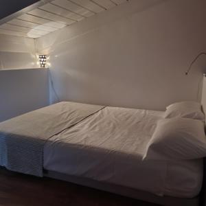 都灵Gaia Suites的白色墙壁的房间里一张白色的床