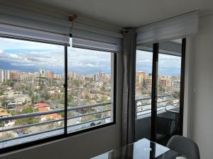 圣地亚哥Depto LAS CONDES-EST ESPAÑOL的客房设有2扇窗户,享有城市美景。