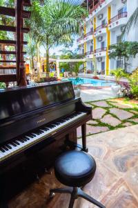 南威Canary Nungwi Hotel & Free SPA的钢琴和泳池旁的凳子