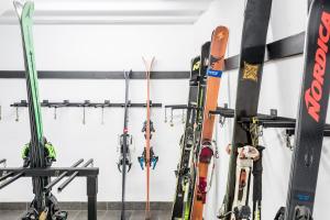 维耶拉Riu Nere Mountain Apartments的一堆滑雪板和滑雪板靠在墙上