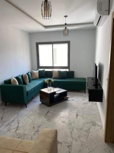 突尼斯Dar Kmar的客厅配有绿色沙发和电视