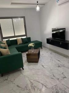 突尼斯Dar Kmar的客厅配有绿色沙发和钢琴