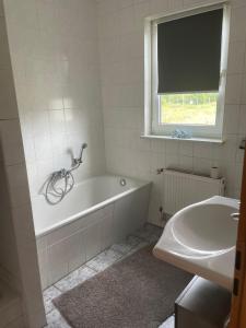 Wohnung in Möser mit Grillmöglichkeit的白色的浴室设有浴缸和水槽。