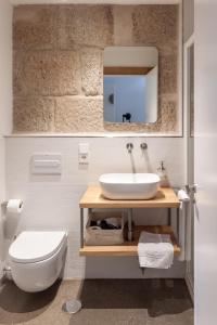 庞特维德拉La Fonda的一间带水槽、卫生间和镜子的浴室
