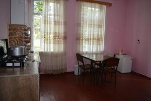 马钦加里Giga Guest House的厨房配有桌椅和窗户。