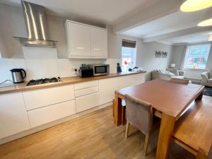胡克Pex Residence: 5-Bedroom Home in Hook的厨房配有白色橱柜和木桌