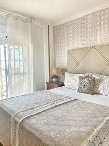 马拉加Luxury Sunny Villa的白色的卧室设有一张大床和一个窗户
