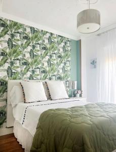 马拉加Luxury Sunny Villa的一间卧室配有一张带热带壁纸的大床