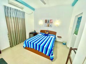 希克杜沃塔马拉汽车旅馆 的一间卧室配有一张带蓝白条纹毯子的床
