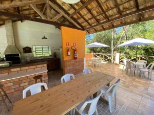 库尼亚Pousada Sotaque Mineiro的庭院配有木桌、椅子和遮阳伞