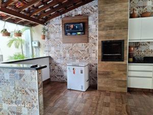 乌贝拉巴Casa de temporada Uberaba piscina的带冰箱的厨房和墙上的电视