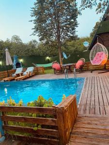萨潘贾Sıcak havuzlu dağ evi的一个带木甲板和桌椅的游泳池
