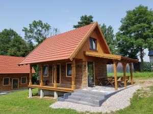 WroceńKraina Biebrzy - domki nad Biebrzą的一座带橙色屋顶的小木屋