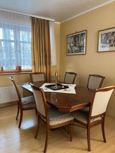 纳尔瓦约埃苏Vabaduse Guesthouse的一间带木桌和椅子的用餐室