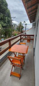 阿布拉奥Residencial 101 Ilha Grande的阳台上的木桌和椅子