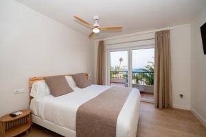 比利亚霍约萨Paradisun Villajoyosa的一间卧室设有一张床和一个阳台的窗户。