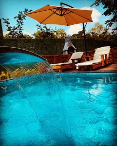 萨潘贾Sıcak havuzlu dağ evi的一个带遮阳伞和桌椅的游泳池