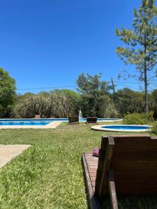 拉巴斯don isidro cabaña的草地庭院的游泳池,有两把长椅