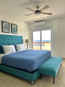 罗阿坦Condominio frente al mar Roatán的一间卧室设有蓝色的床和大窗户