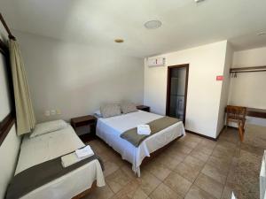 萨尔瓦多Pousada Maristella的一间卧室配有两张床和椅子