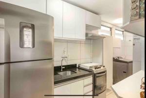 累西腓Coração de Boa Viagem的厨房配有白色橱柜和不锈钢冰箱