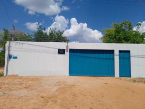 Sao Miguel do AraguaiaRancho peixe grande的土路上带蓝色门的白色围栏