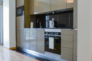 里斯本Lisbon Brown Cozy Apartment的厨房配有不锈钢烤箱和橱柜。
