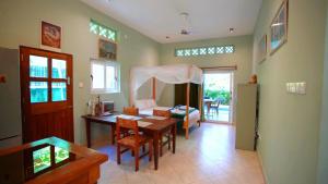 迪亚尼海滩The Pool House & The Colobus House, Bella Seaview, Diani Beach, Kenya的一间带桌子的客厅和一间卧室