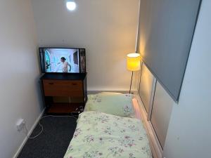 水晶宫Rooftop Apartment的小房间设有床铺和电视