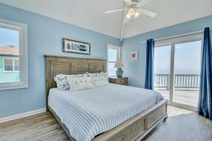 罗丹特7048 - Tide Song by Resort Realty的一间卧室配有一张蓝色墙壁和窗户的床