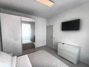福利尼奥Casa Vacanze Il Divano Rosso的卧室配有一张床,墙上配有电视