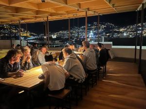 基多Community Hostel Quito的一群人晚上坐在餐馆的桌子上