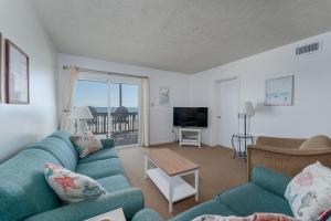 罗丹特7055 - Hatteras High 8C by Resort Realty的客厅配有蓝色的沙发和电视