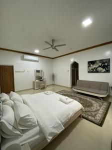 尼兹瓦Mountain Balcony House的卧室配有一张白色的大床和一张沙发。