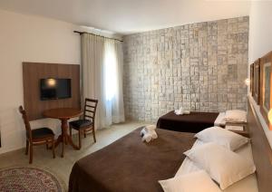 伊塔蒂亚亚伊塔蒂埃亚拉蓬萨酒店的酒店客房设有两张床和一张桌子。