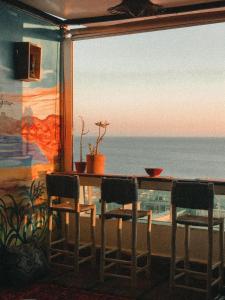 塔哈佐特Sunrise Hostel Taghazout的一张桌子和椅子,享有海景