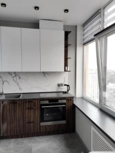 敖德萨Board apart hotel的厨房配有木制橱柜和白色家电
