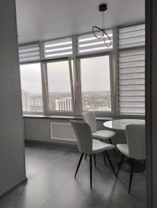敖德萨Board apart hotel的一间带桌椅和窗户的用餐室