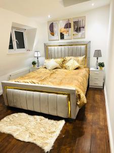 伦敦Luxury Morden 4 bedroom Flats which will make you unforgettable的卧室内的一张大床,配有金色床单和枕头