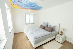 BurtenbachFerienparadies Amadeus的一间卧室配有一张天花板上绘画的床