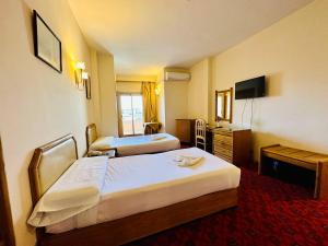 卢克索Queens Valley Hotel的酒店客房设有两张床和电视。