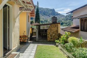 彼得罗波利斯Chamosa e aconchegante casa em Petrópolis VGL041的通往山地房子的门道