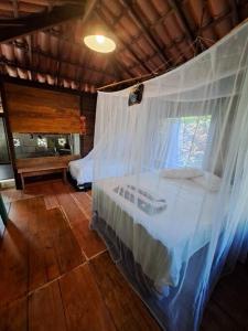 马塔迪圣若昂Chalé com privacidade em Imbassai的一间卧室配有一张带天蓬和窗户的床